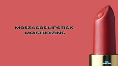 The image shows a red lipstick with a smooth, shiny surface, standing upright on the right side. The background is a matching red color. The text "MOSZACOS LIPSTICK MOISTURIZING" is centered on the left side of the image in bold, black, and white-outlined capital letters. At the bottom of the lipstick, there is a small logo with the words "THE RATINGS GURU."