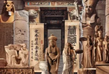 Ancient Artz: An intricate and diverse display of ancient cultural artifacts and statues from various civilizations, positioned within a grand, historical setting. The scene includes detailed carvings on stone pillars and sculptures, representing Egyptian, Greco-Roman, and Asian influences. Hieroglyphs and ancient Chinese calligraphy scrolls are prominently featured alongside statues of deities and historical figures. The background showcases an ornately decorated stone archway, suggesting a connection between these cultures in a timeless, archaeological setting.