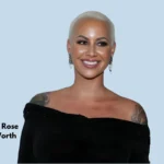 Amber Rose smiling in a black off-shoulder outfit with the phrase 'Amber Rose Net Worth' written beside her, reflecting her successful career in modeling, acting, and entrepreneurship.