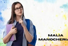 Malia Manocherian standing confidently, wearing glasses and holding a notebook close to her chest. She has a thoughtful expression, with one hand resting on her chin, as if pondering an idea. Dressed casually in a navy blue top and light blue button-up, she carries a blue backpack over her shoulders. Her name, 'Malia Manocherian,' appears on the right side in bold black letters, set against a colorful watercolor background of blues, yellows, and oranges. The Ratings Guru logo is displayed in the top right corner.