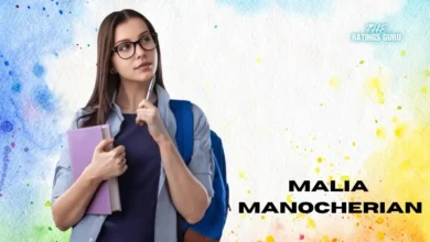 Malia Manocherian standing confidently, wearing glasses and holding a notebook close to her chest. She has a thoughtful expression, with one hand resting on her chin, as if pondering an idea. Dressed casually in a navy blue top and light blue button-up, she carries a blue backpack over her shoulders. Her name, 'Malia Manocherian,' appears on the right side in bold black letters, set against a colorful watercolor background of blues, yellows, and oranges. The Ratings Guru logo is displayed in the top right corner.