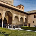 A stunning courtyard in the Alhambra, Granada, Spain, showcasing intricate Moorish arches, carvings, and a reflecting pool, perfect for a 3-day travel guide and itinerary to explore the rich history of Granada.