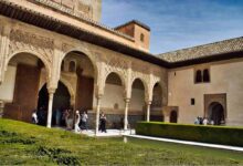 A stunning courtyard in the Alhambra, Granada, Spain, showcasing intricate Moorish arches, carvings, and a reflecting pool, perfect for a 3-day travel guide and itinerary to explore the rich history of Granada.