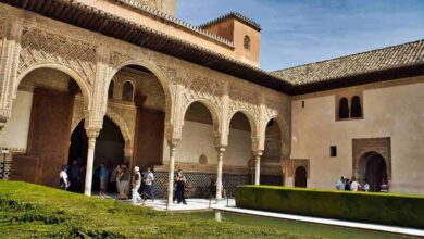 A stunning courtyard in the Alhambra, Granada, Spain, showcasing intricate Moorish arches, carvings, and a reflecting pool, perfect for a 3-day travel guide and itinerary to explore the rich history of Granada.