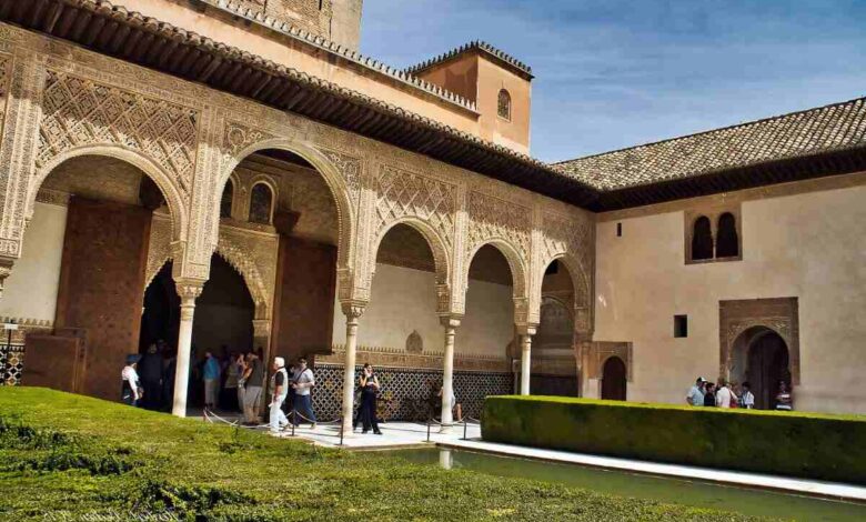 A stunning courtyard in the Alhambra, Granada, Spain, showcasing intricate Moorish arches, carvings, and a reflecting pool, perfect for a 3-day travel guide and itinerary to explore the rich history of Granada.