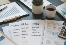 An organized desk featuring financial documents, a retirement planning notebook, a calculator, and tax forms, representing different types of IRAs such as Traditional, Roth, SEP, SIMPLE, and Rollover IRAs. A graph showing financial growth and a cup of coffee highlight strategic retirement planning.